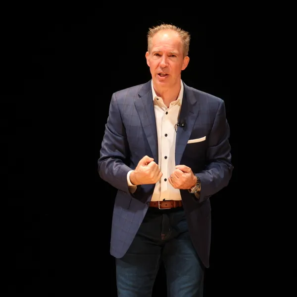 David Lee Jensen making a driven point on stage, hands clenched